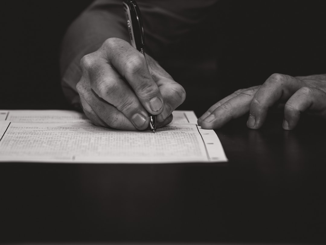 Person reviewing a contract document with a pen in hand