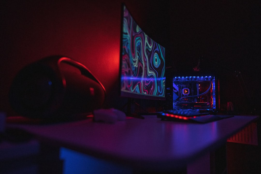 Gaming setup with RGB-lit monitor and controller on a desk
